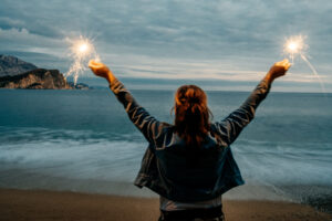 young happy smiling woman holding sparkler